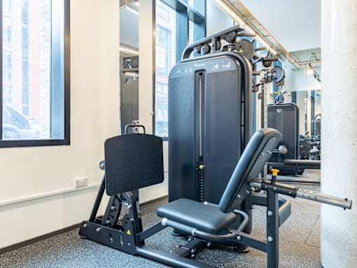 A gym with a black weight bench and a black weight rack.