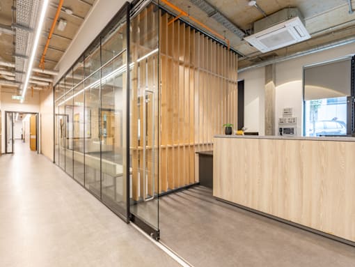 A long hallway with glass walls and wood paneling.