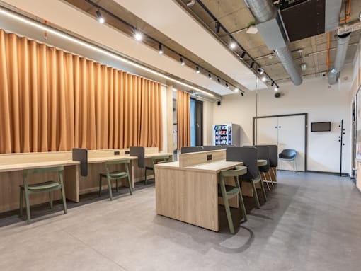 A conference room with orange curtains and a long table with chairs.
