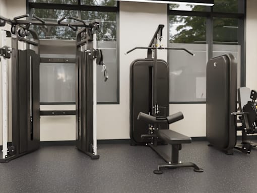 A gym with a variety of equipment including a squat rack, a leg press machine, and a bench.