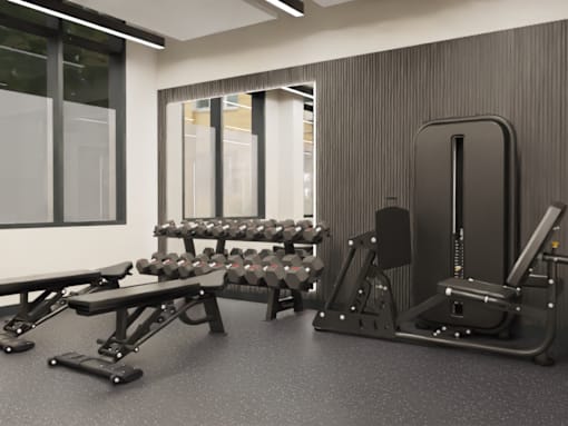 A gym with a variety of equipment including weights and a bench.