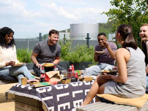 A group of people enjoying a picnic on a blanket with a "GLEN" logo.