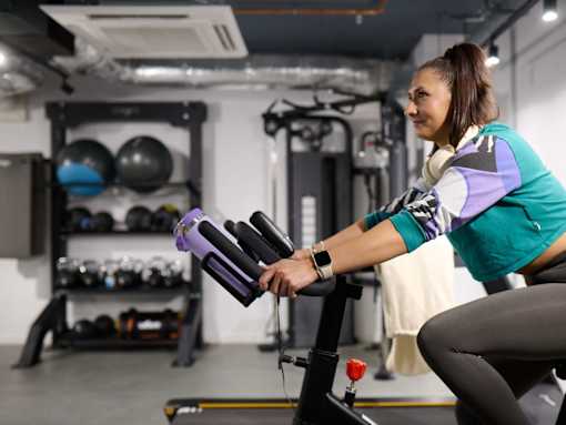 A woman is working out on a rowing machine in a gym.