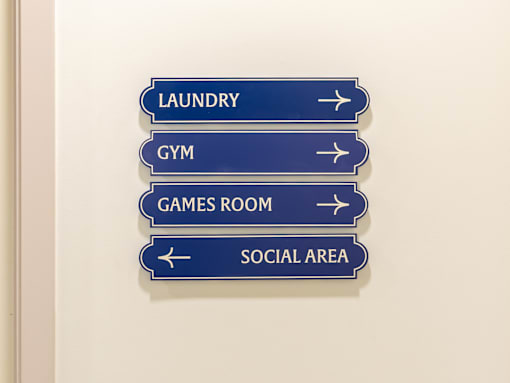 A sign with four directions to Laundry, Gym, Games Room and Social Area.