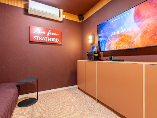 A room with a red wall and a sign that says "Live from Stratford" is shown.