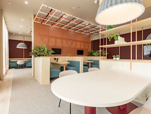 A modern dining area with a white table and blue chairs.