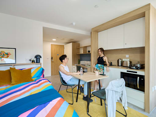 Two people are sitting at a table in a colorful room.