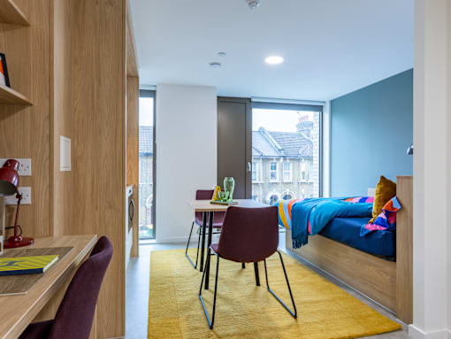 A room with a bed, desk, and chair.