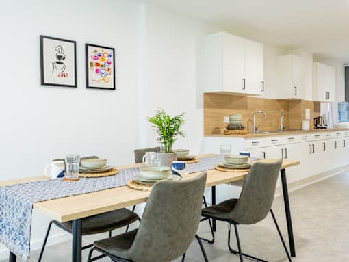 A dining area with a table set for two and a plant on the table.