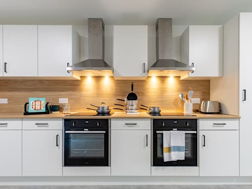 A modern kitchen with black and white appliances and wooden accents.