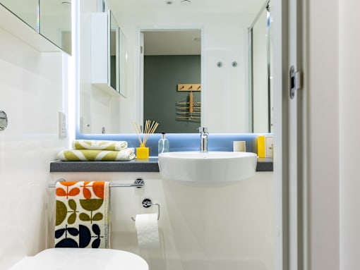 A white sink in a bathroom with a towel on the counter.