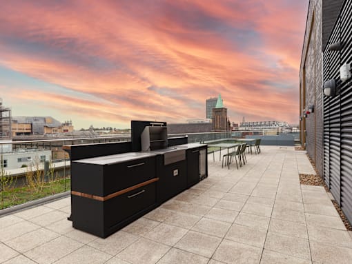 A rooftop patio with a large grill.