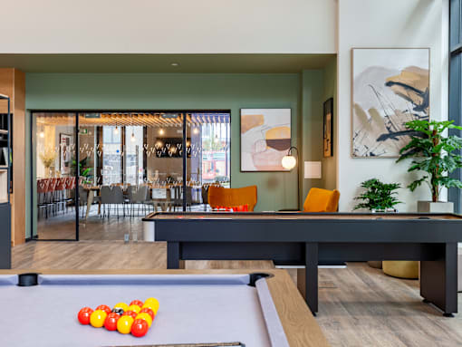 A social area with shuffleboard and pool table.