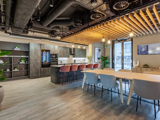 Shared kitchen with a long dining table and bar with bar stools.