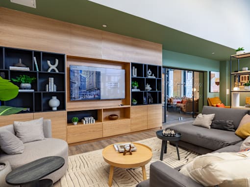A social area with grey couch and television.