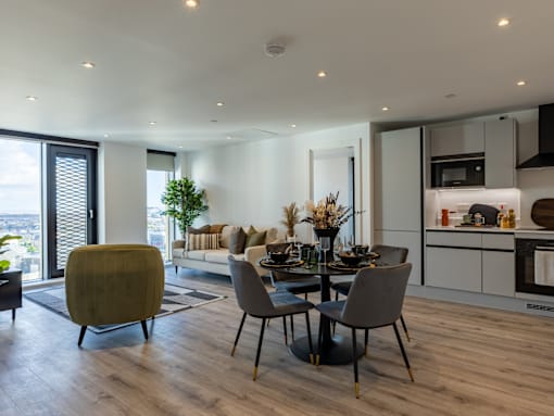 Kitchen and living pace, with sofa and round dining table with chairs.