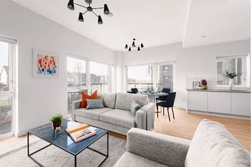 a living room with a gray couch and a glass coffee table