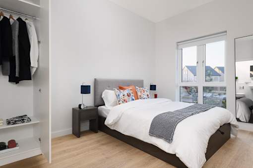 a bedroom with a bed and a closet and a window