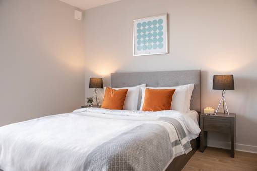 a bedroom with a white bed and orange pillows