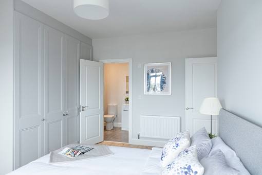 a bedroom with a bed and a door to a bathroom