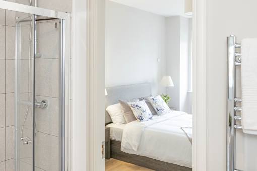 a bedroom with a bed and a glass shower