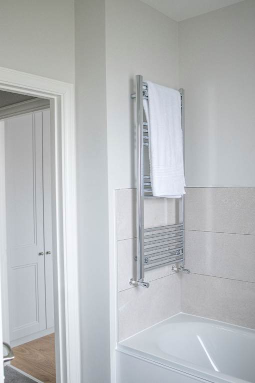 a bathroom with a shower and a towel rack and a sink