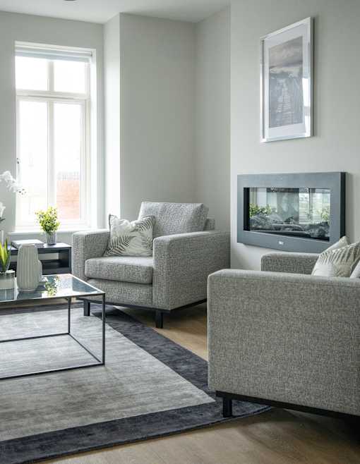 a living room with two chairs and a television