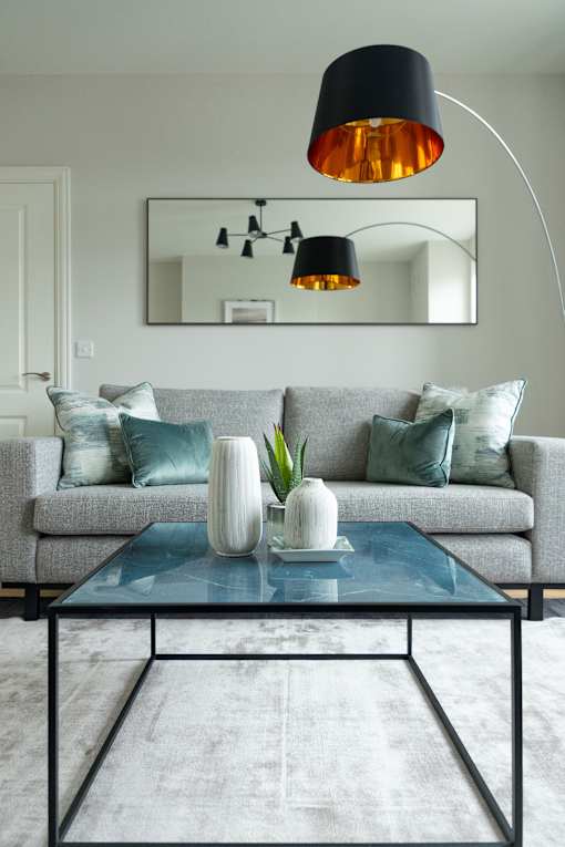 a living room with a gray couch and a glass coffee table