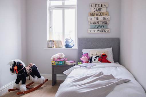 a bedroom with a bed with stuffed animals on it