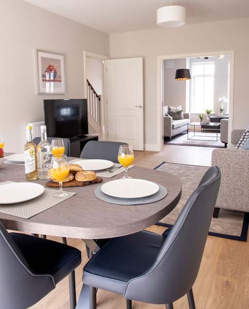 a dining room table with plates of food and glasses of orange juice