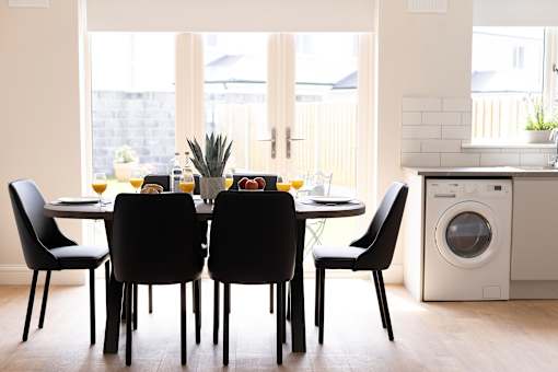 a dining room with a table and chairs and a washing machine