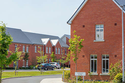 a row of red brick houses with cars parked in front of them