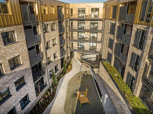 an aerial view of an apartment building with a walkway in the middle