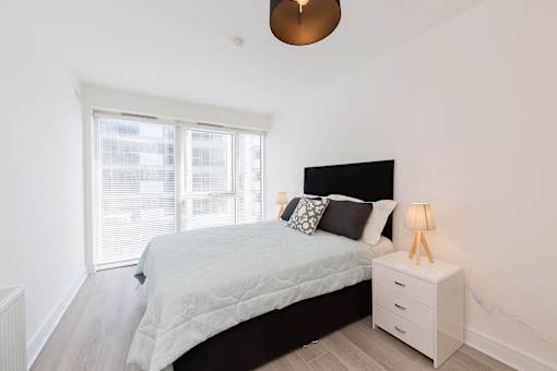 a bedroom with a bed and a large window