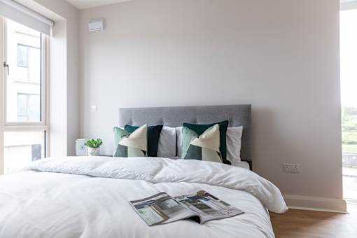 a bedroom with a bed with pillows and a magazine on it