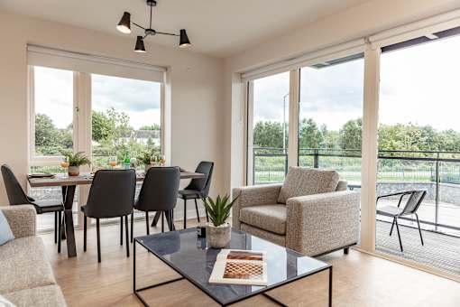 a living room with a table and chairs and a balcony