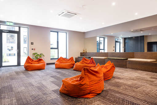 a large room with orange couches and a reception desk