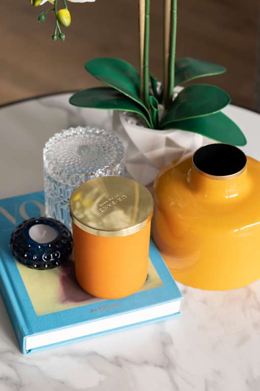 a table with a yellow vase and a book on it