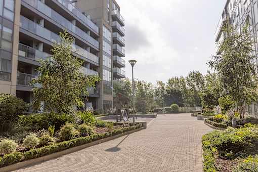 a park with benches and trees in front of a building