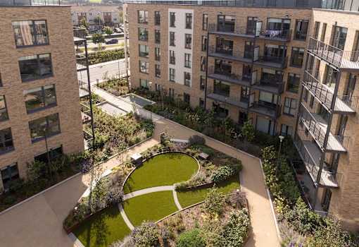 an aerial view of a green courtyard surrounded by apartment buildings