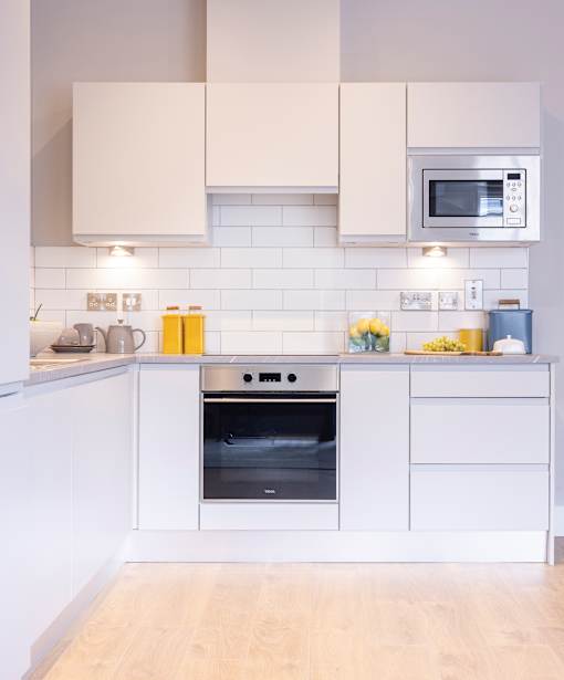 a white kitchen with a stove and a microwave