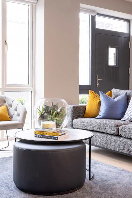 a living room with couches and a coffee table with a flower arrangement on it