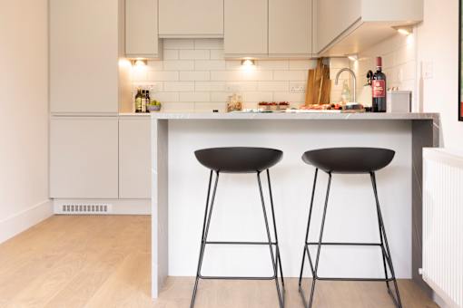 two black bar stools in front of a kitchen counter