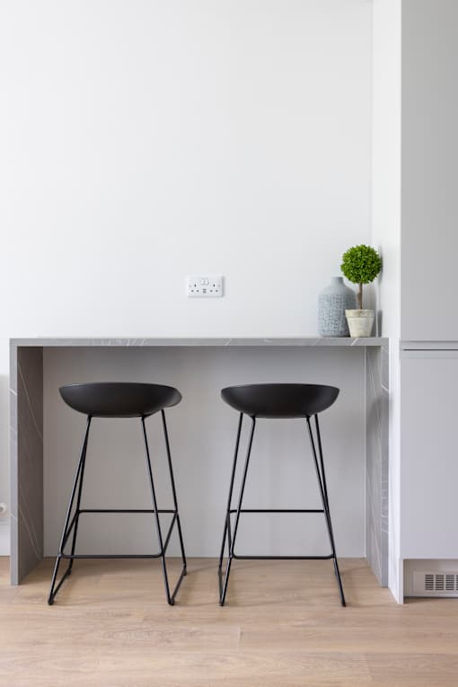 two black bar stools under a kitchen counter