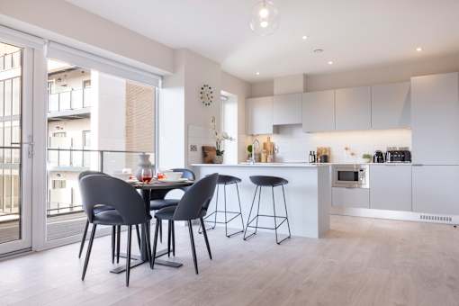 a kitchen with white cabinets and a table with three stools