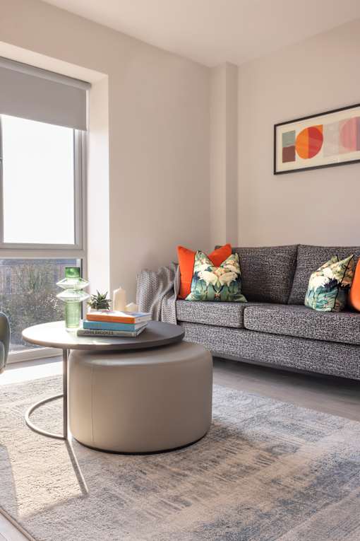 a living room with a gray couch and a round coffee table