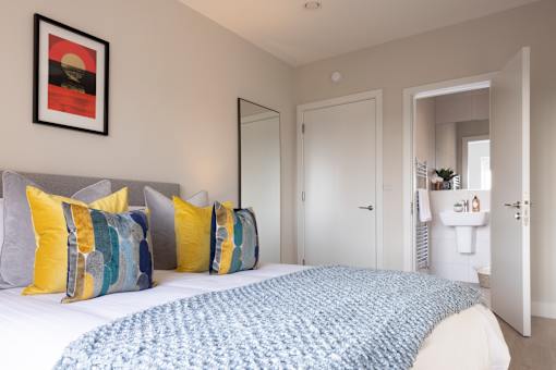 a bedroom with a large bed and a bathroom with a sink