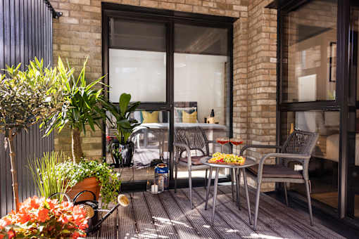 a balcony with a chair and a table and a bed