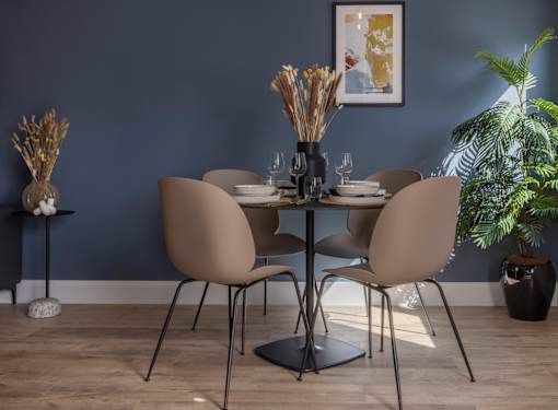 a dining room with a table and chairs and a blue wall