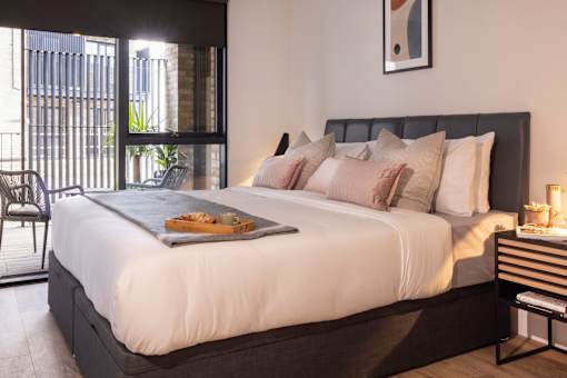 a bedroom with a large bed and a balcony